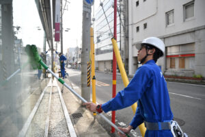 展示用の枠のない大きなガラスには、専用の器具で効率よく実施します。
なお、外側での作業中は通行している車からもよく見られますので、会社の広告塔としての自覚をもって作業しています。